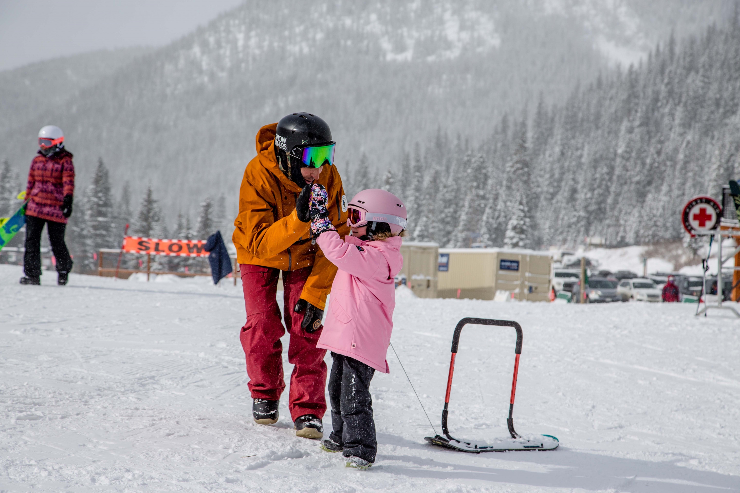AASI Team Member Tony Macri high fives a young student in a snowboard lesson