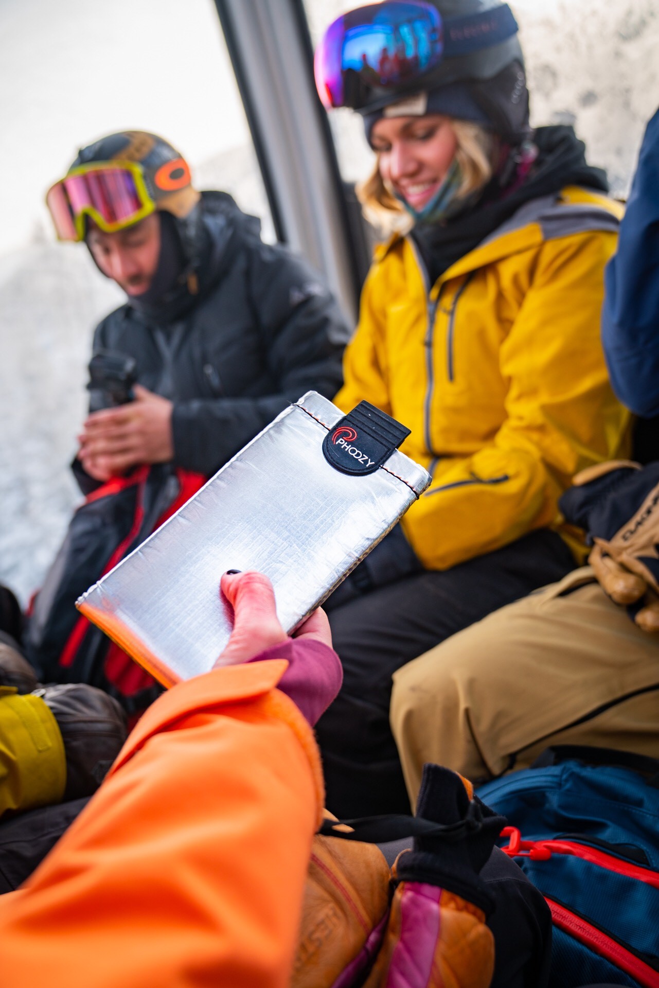 A gondola rider holds up their phone encased in a phoozy case
