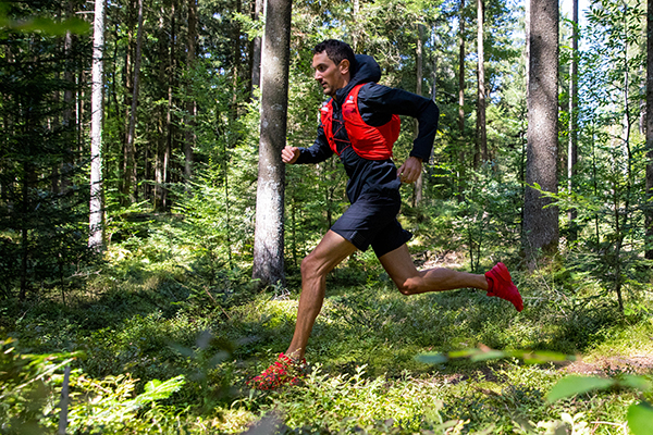 A Salomon trail runner sprints in the woods
