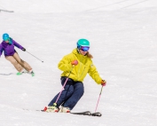 PSIA-AASI National Team Member Robin Barnes demonstrates for her student skiing behind her