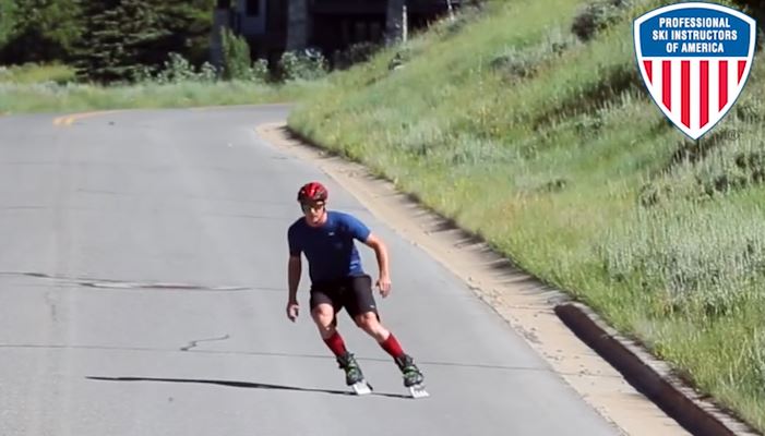 Inline skating down a road, a man on Rollerblades demonstrates similiarities to skiing.