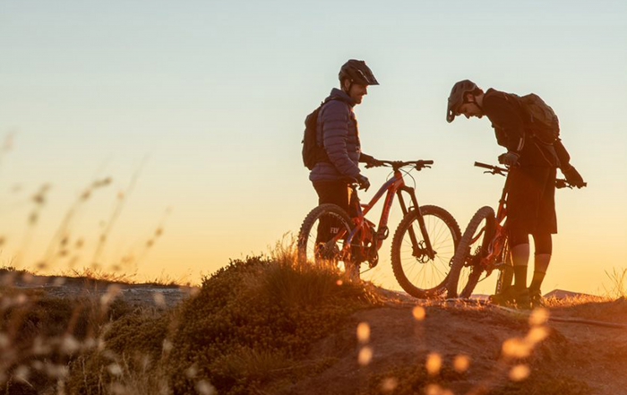 Two mountain bikers on Rossignol bikes at dusk.