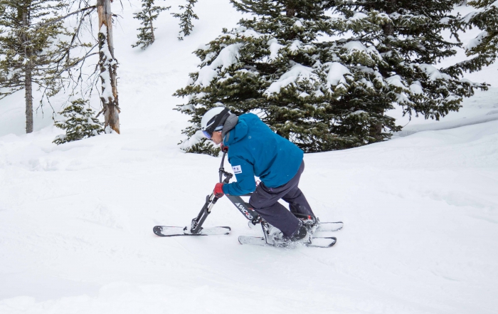 A ski instructor rides a sno-go down the slope.