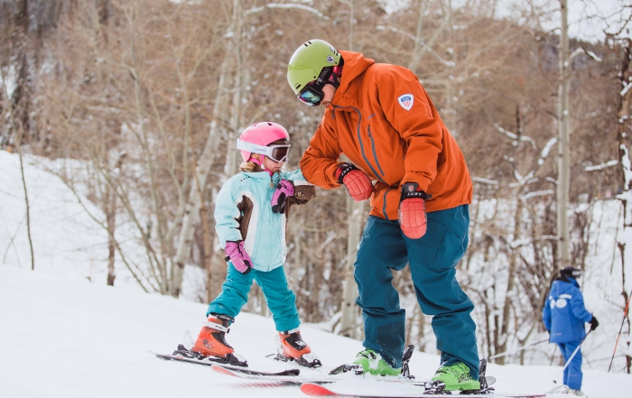 A girl and her ski instructor elbow bump