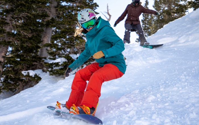 two female snowboarders shred