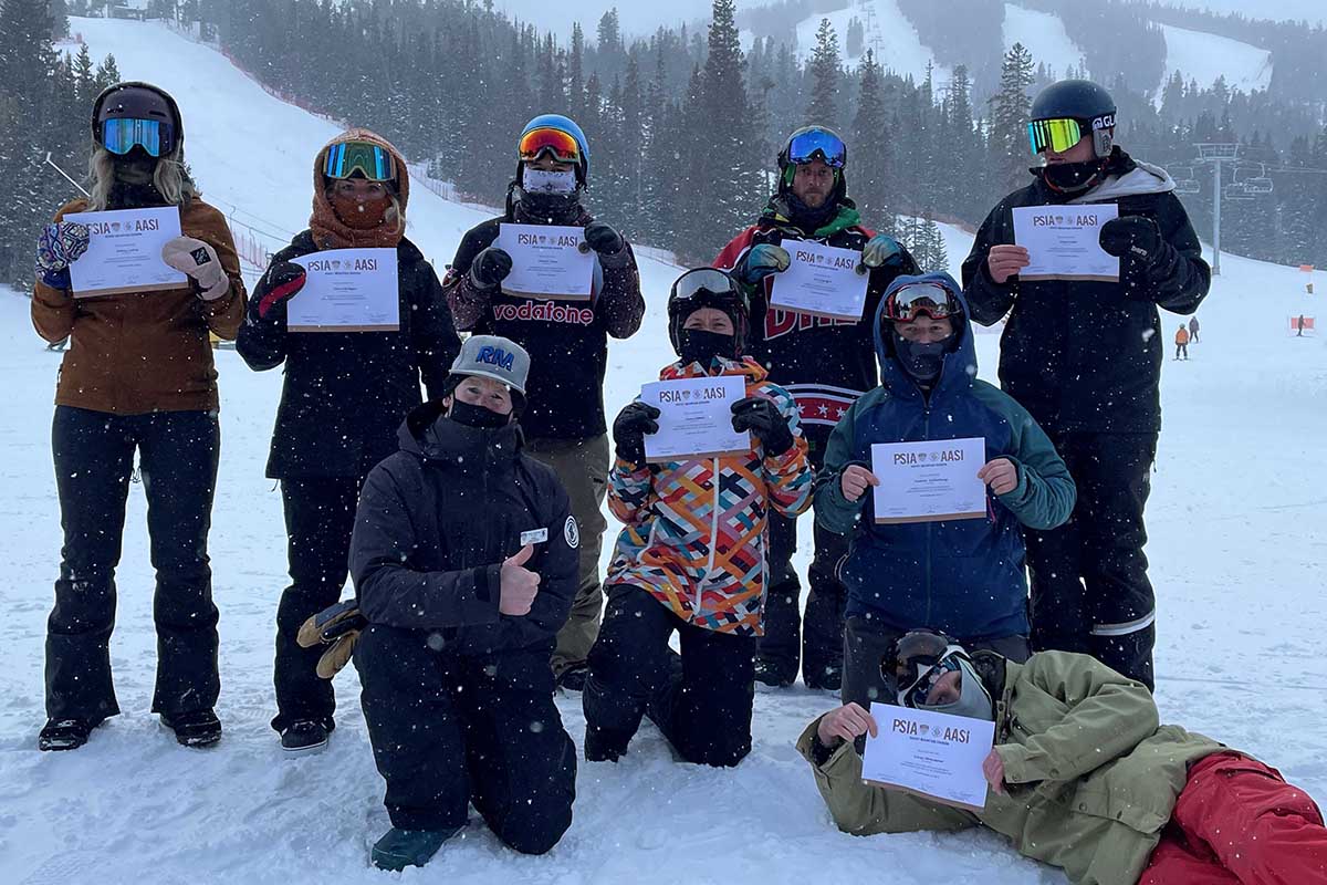 Rocky mountain AASI Level I snowboard instructors hold their certificates