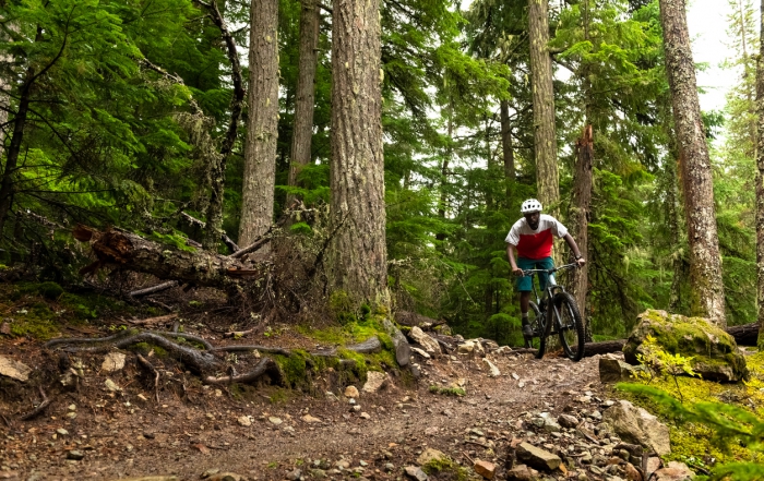 African American athlete riding a mountain bike. Best biking destinations in North America. Living an active lifestyle.