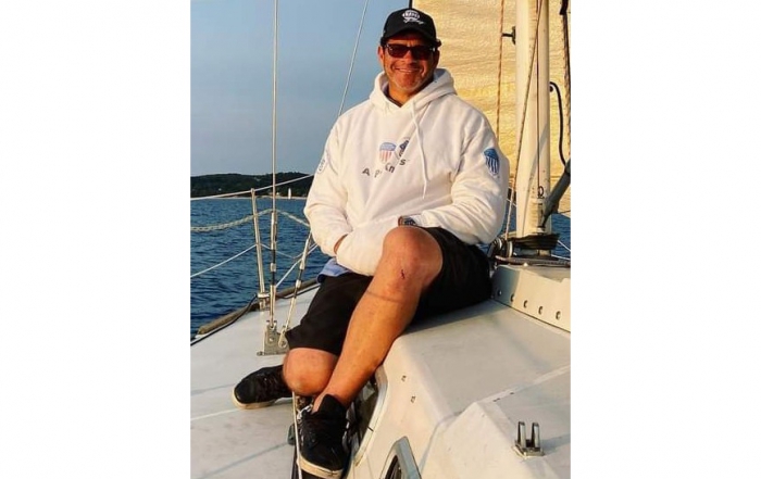 Ron Shepard sits on a sailboat