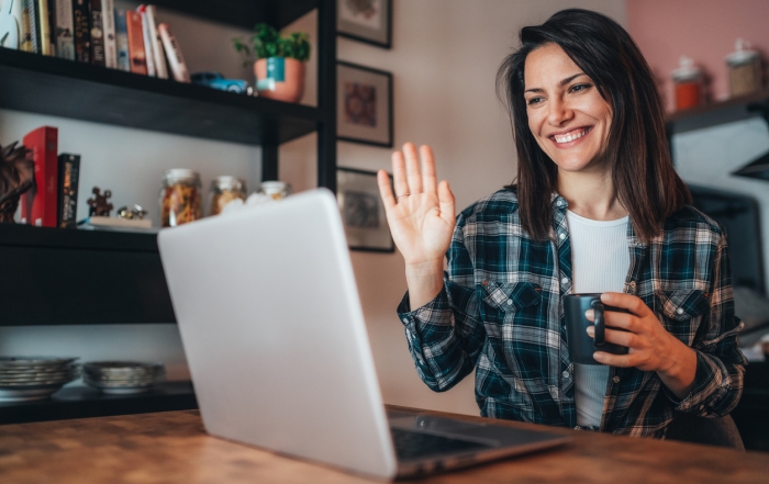 Young woman using a laptop to connect with her friends for video conference