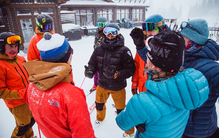 a group a ski instructors talk and train in a circle