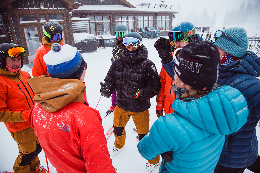 a group a ski instructors talk and train in a circle