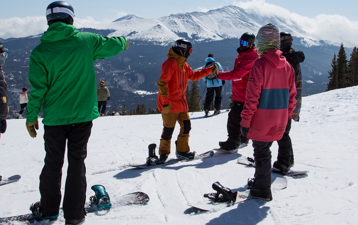 snowboarders take a lesson to learn to snowboard