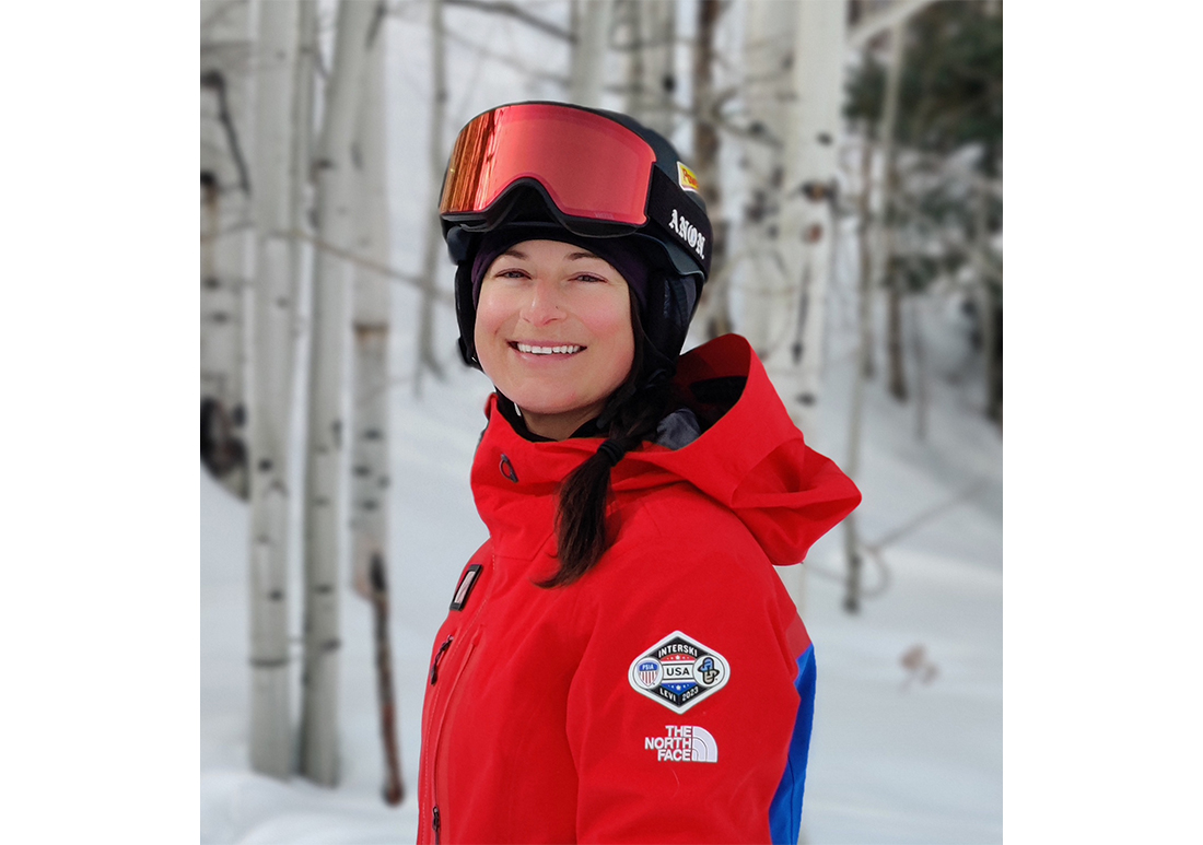 Christina Bruno, a member of the PSIA Adaptive Team poses in front of Aspen trees in the snow