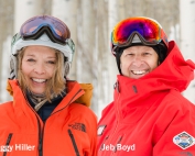 Peggy Hiller and Jeb Boyd pose in the north face snow gear in front of aspen trees in vail colorado with snow on the ground