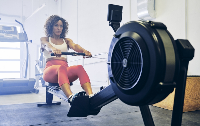 Woman Practicing Fitness In Summer on Rowing Machine for Injury Prevention for Winter
