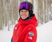 PSIA-AASI National Team member Stephanie Wilkerson poses on snow in front of Aspen trees.