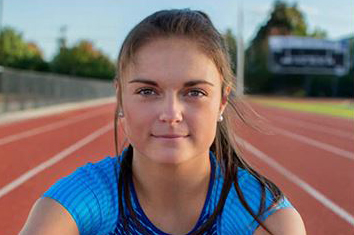 U.S. Paralympic athlete Noelle Lambert with running track behind her.