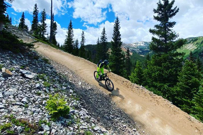 Downhill mountain biker on mountain trail.