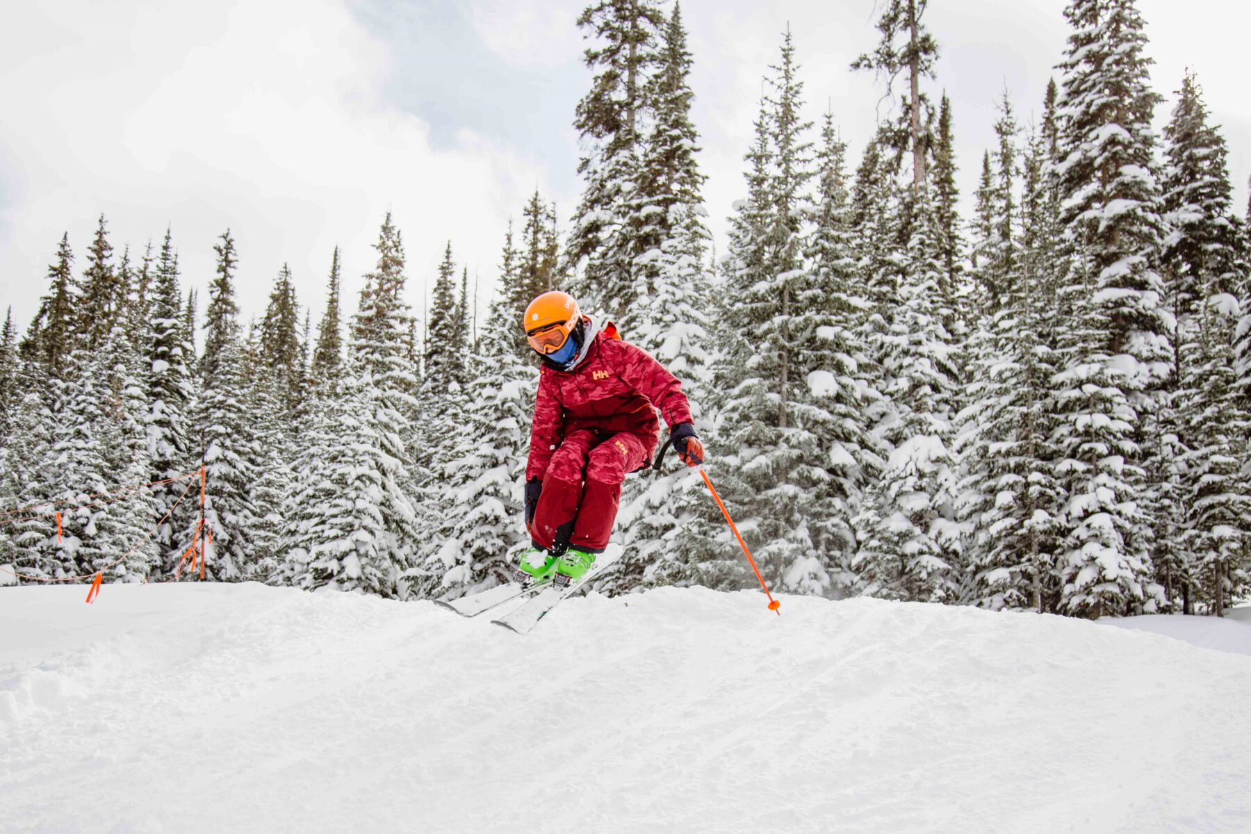 Teen skier jumps off the side bank of a run and does a tail grab