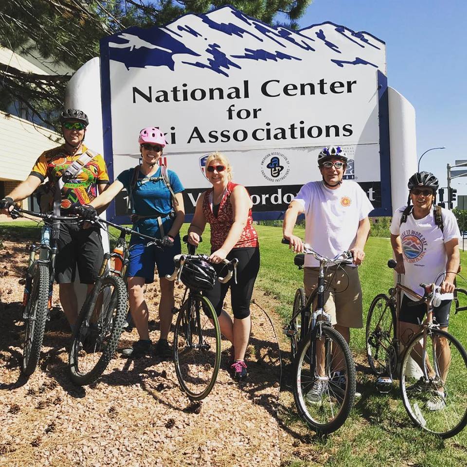 Staff of the PSIA-AASI National Office stand in front of the building with their bikes