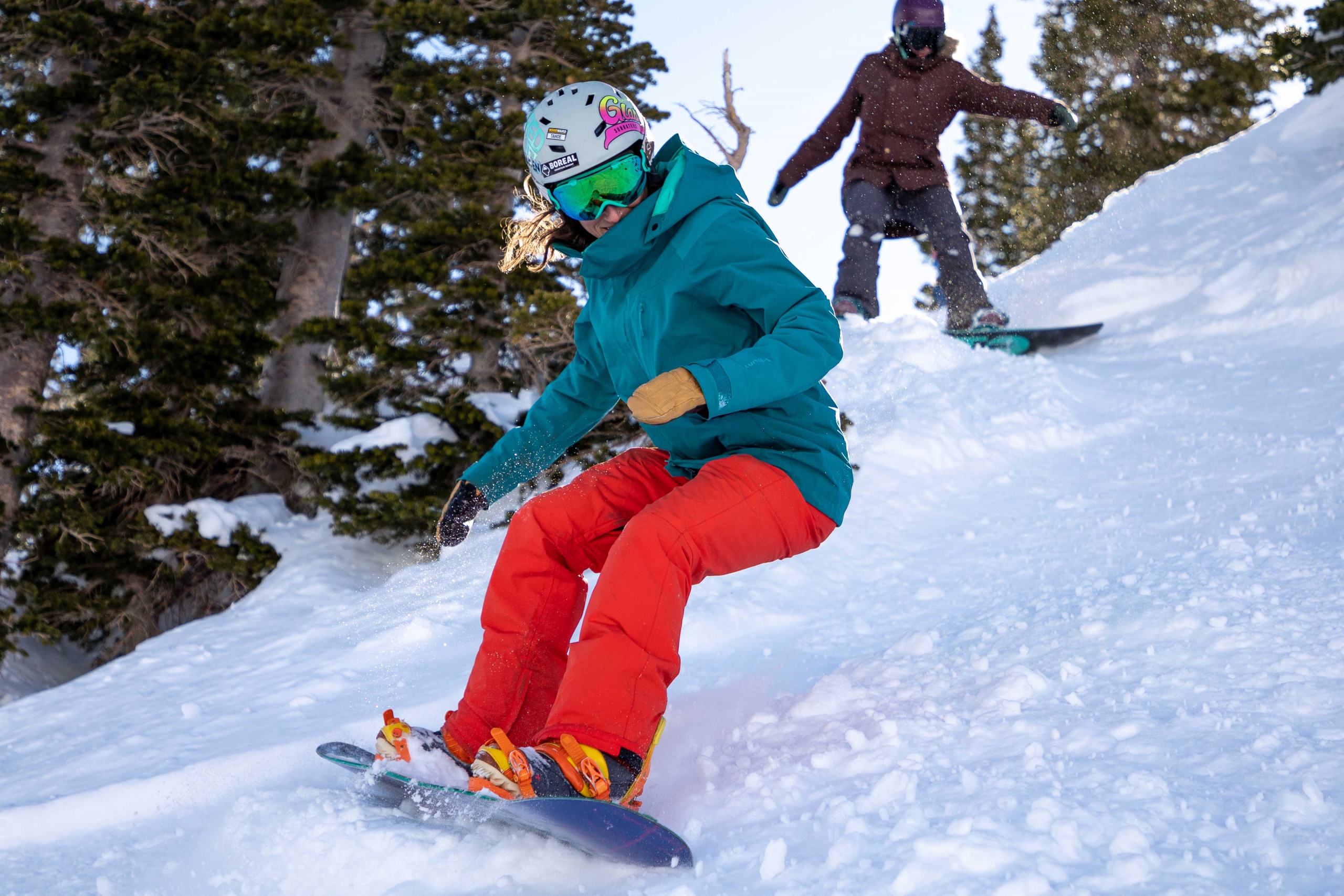two female snowboarders shred