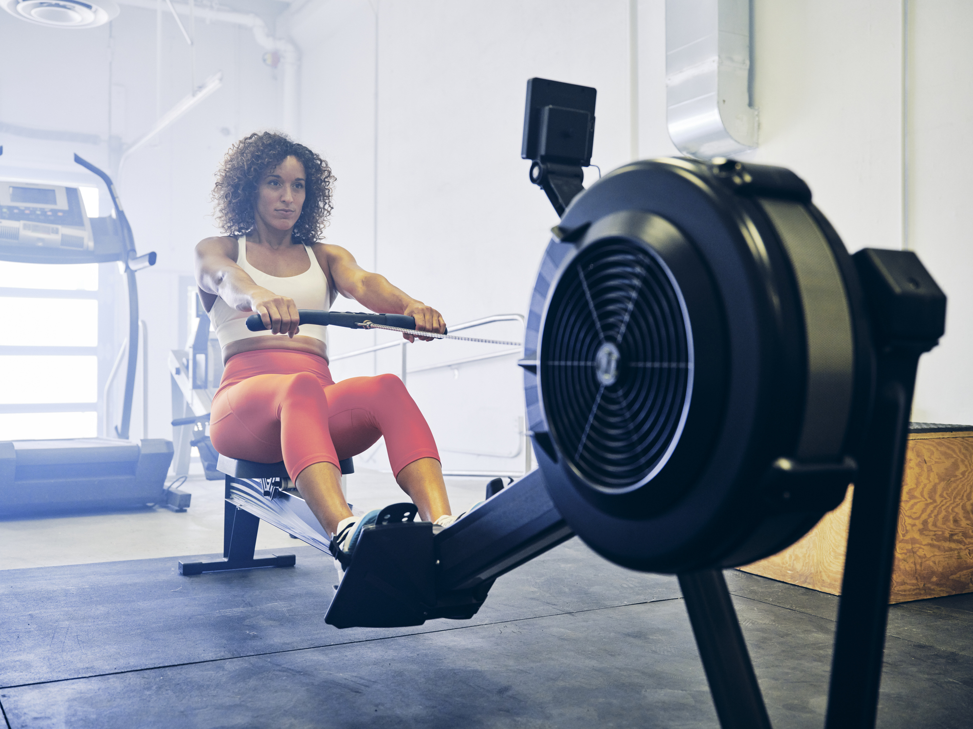 Woman Practicing Fitness In Summer on Rowing Machine for Injury Prevention for Winter