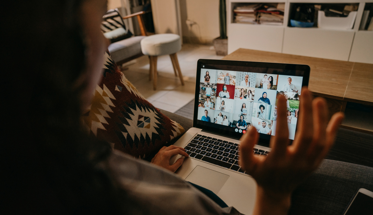 Woman using a laptop on the sofa at home to participate in a web