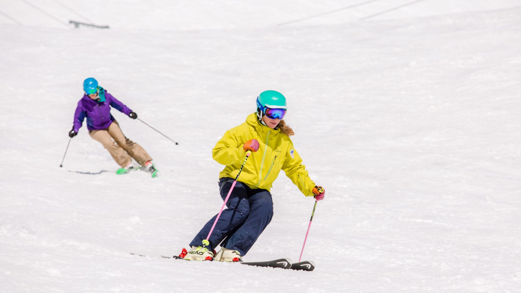 PSIA-AASI National Team Member Robin Barnes demonstrates for her student skiing behind her
