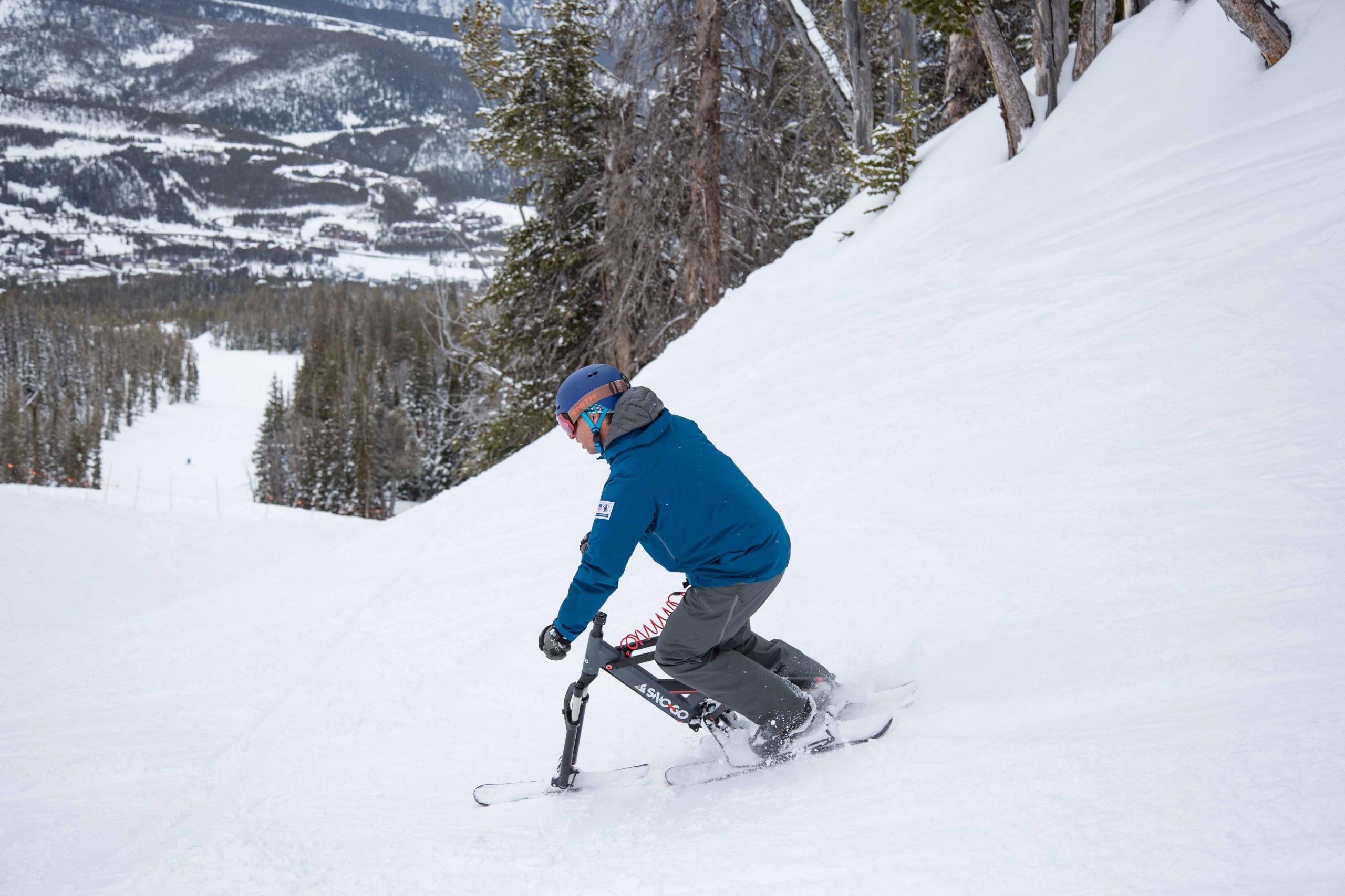 A sno-go rider descends the ski slope