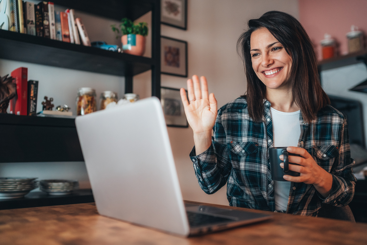 Young woman using a laptop to connect with her friends for video conference
