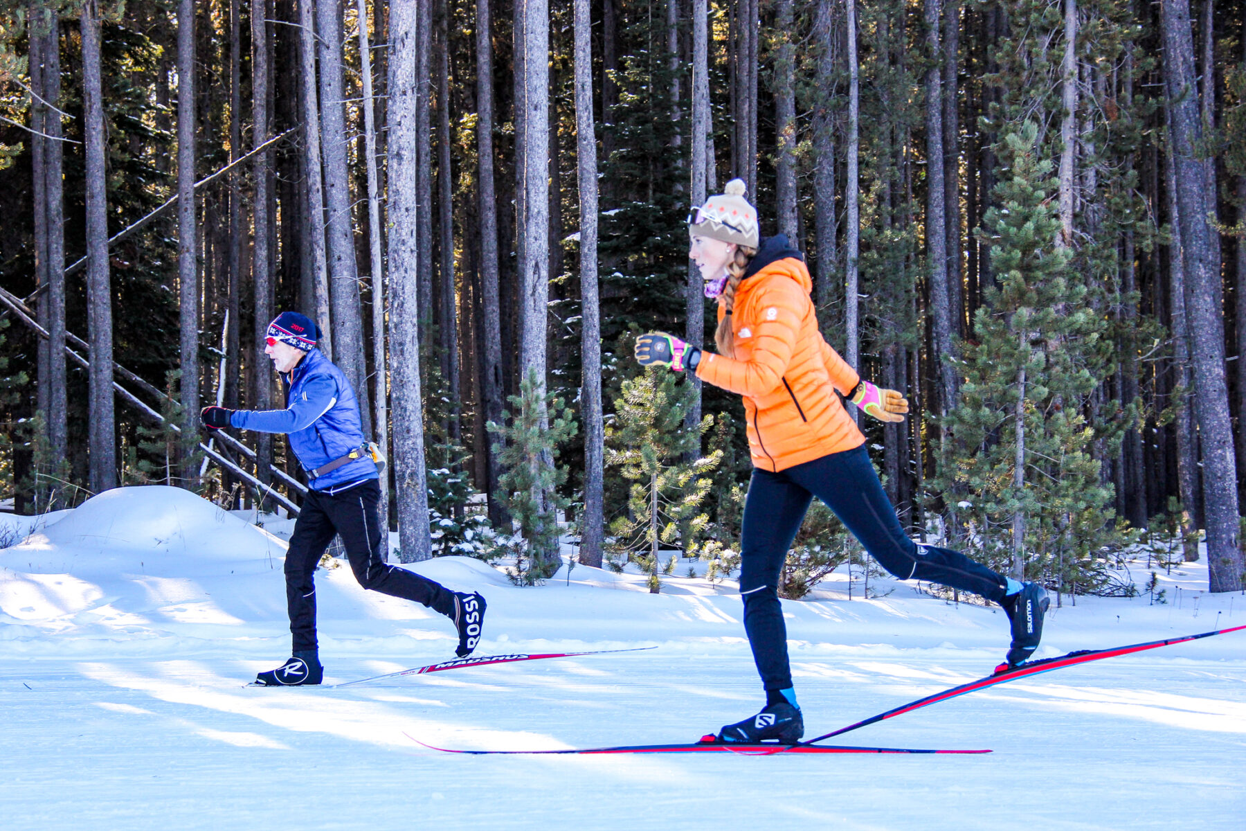 Two cross country skiers practicing classic skiing.