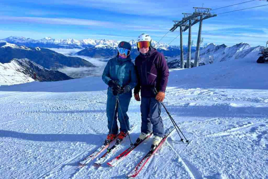 two skiers posing on a slope.