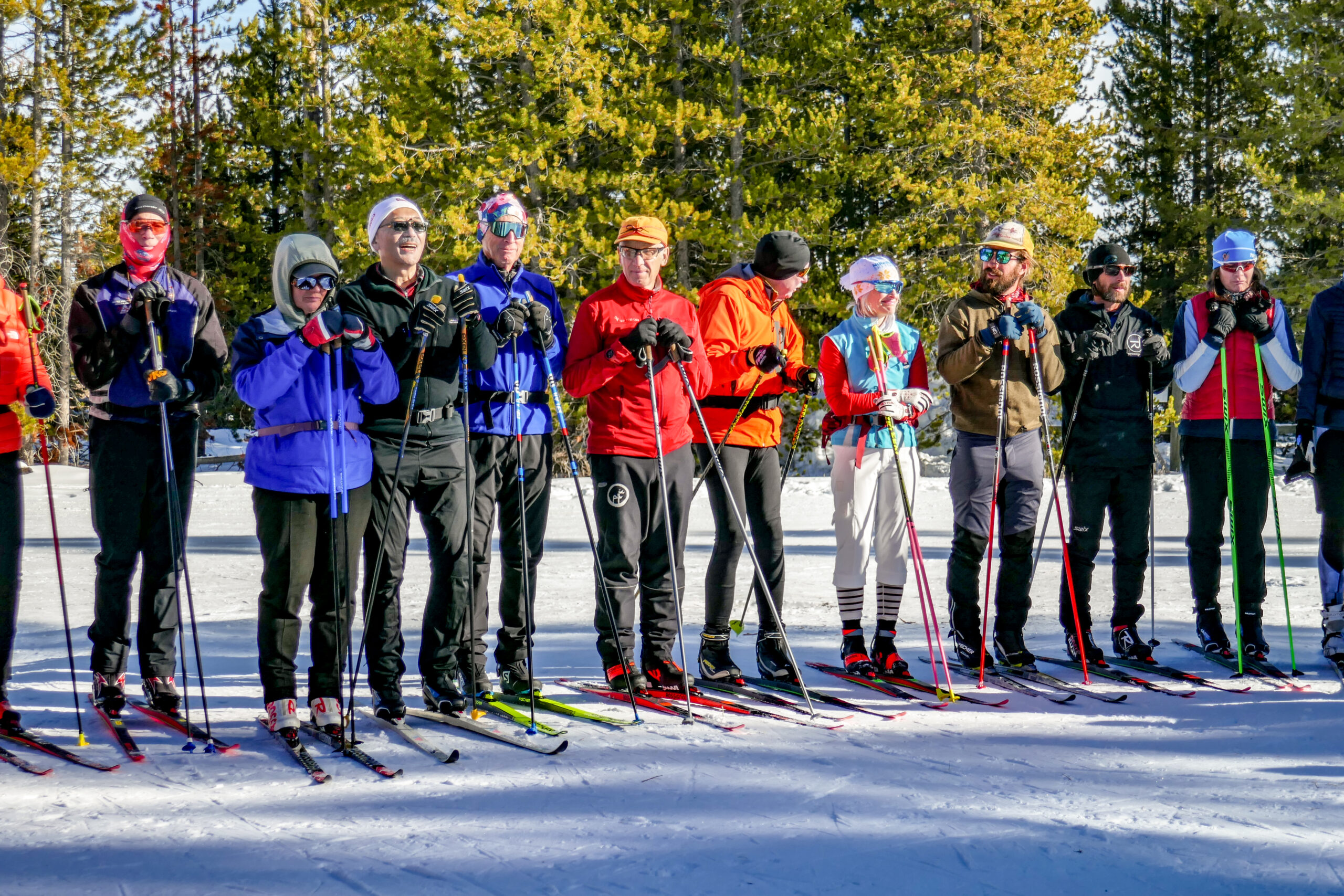 A group of cross country skiers standing on snow.